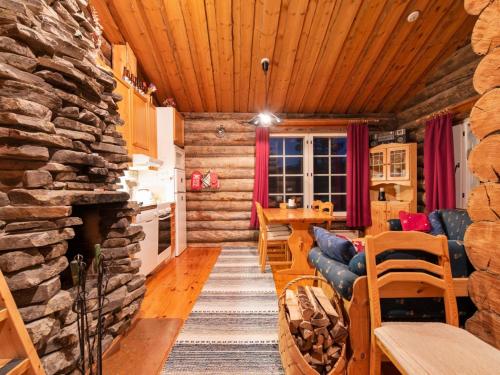 a log cabin living room with a stone fireplace at Holiday Home Lomaylläs d59 -palovaarankaarre 13 a by Interhome in Ylläsjärvi