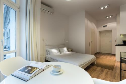 una camera d'albergo con due letti e un tavolo con un libro di Apartament Centrum HGa - Garbary a Poznań
