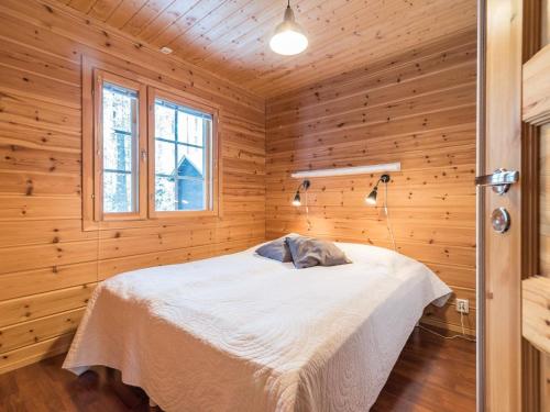 ユッラスヤルヴィにあるHoliday Home Kultapiisku 3 by Interhomeの木製の部屋にベッド1台が備わるベッドルーム1室があります。