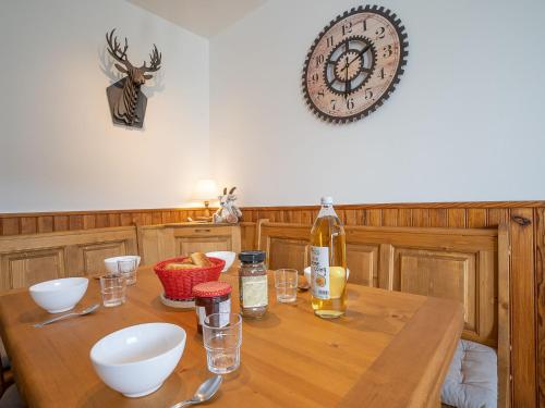 einen Holztisch mit einer Flasche Wein und Gläsern in der Unterkunft Apartment Les Lauzes D12 by Interhome in Les Menuires