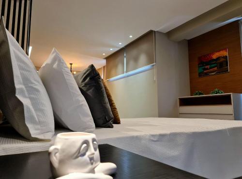a room with a bed with pillows and a head on a table at Seasons BC in Cabeçudas