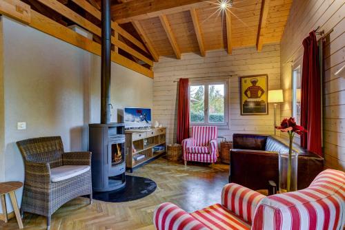 a living room with a fireplace and a couch and chairs at Chalet du Bourg in La Tzoumaz