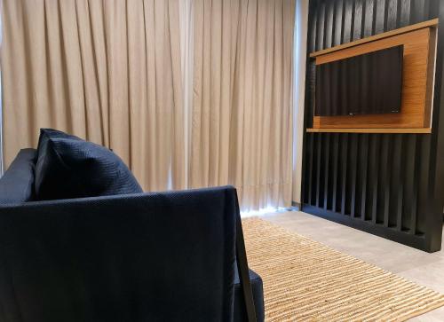 a living room with a chair and a television at Seasons BC in Cabeçudas