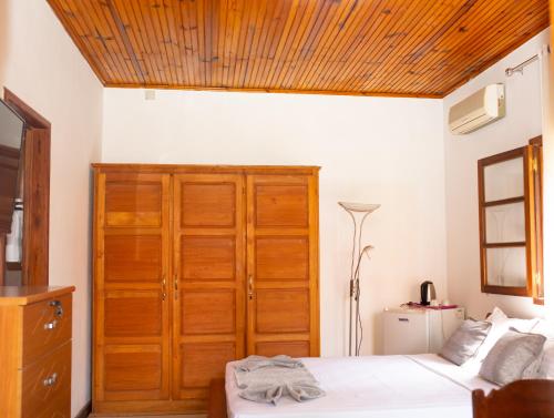 - une chambre avec un placard en bois et un lit dans l'établissement Victory Hotel & Restaurant Tulear, à Toliara