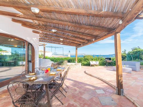 un patio con mesa y sillas bajo una pérgola de madera en Villa Anita by Interhome, en Palau