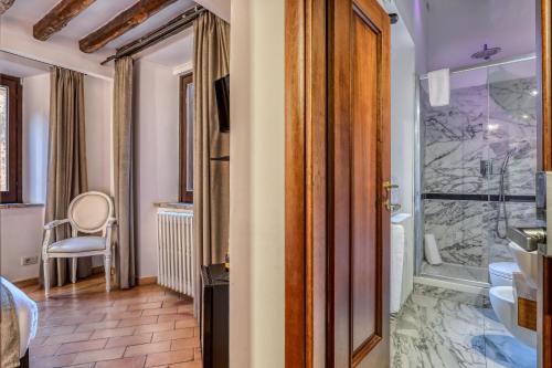 La salle de bains est pourvue d'une douche à l'italienne et d'une douche en verre. dans l'établissement Luxury Navona, à Rome