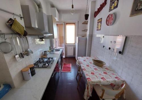 Il comprend une cuisine équipée d'une table, d'une cuisinière et d'un comptoir. dans l'établissement Grazioso monolocale, à Milan