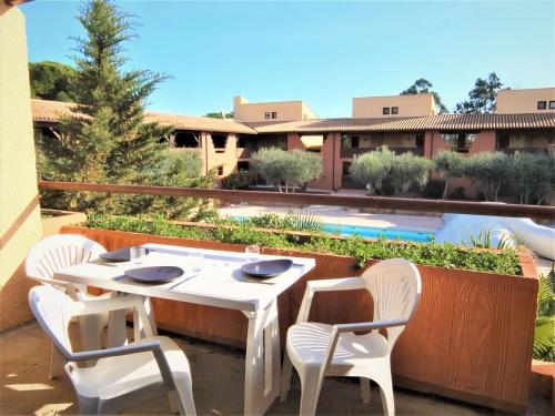 - une table et des chaises sur une terrasse à côté de la piscine dans l'établissement Studio du Golf-7 by Interhome, à Saint Cyprien Plage