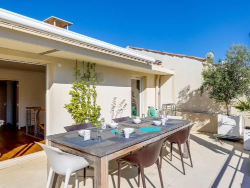 ein Holztisch und Stühle auf einer Terrasse in der Unterkunft Apartment Cap Marine-3 by Interhome in Cavalaire-sur-Mer