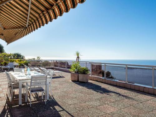 - une table avec des chaises et une vue sur l'océan dans l'établissement Apartment Les Balcons d'Eze by Interhome, à Èze