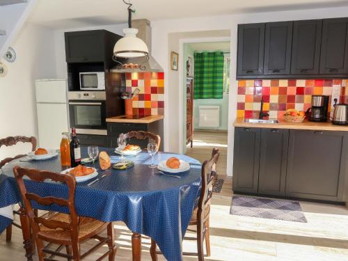 eine Küche mit einem Tisch und einem blauen Tischtuch in der Unterkunft Holiday Home Ty va Zud by Interhome in Lampaul-Ploudalmézeau