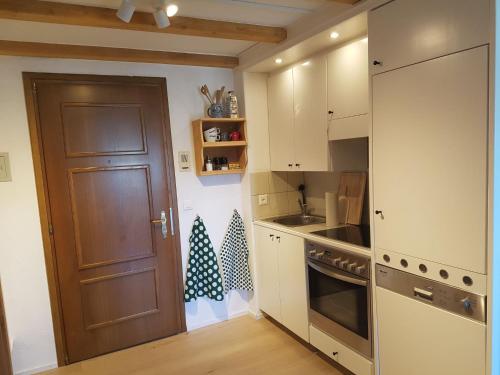ズルレイにあるApartment Residenza Chesa Margun 58-4 by Interhomeの白いキャビネットと茶色のドア付きのキッチン
