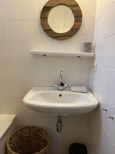 a bathroom with a sink and a mirror on the wall at Vakantiewoning 'Eysinga State' in Sint Nicolaasga