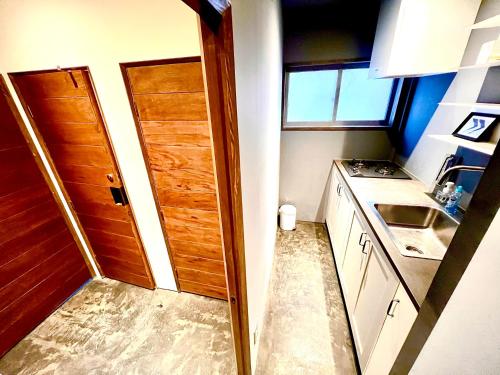 a small kitchen with a door and a sink at Swiss Inn in Sapporo