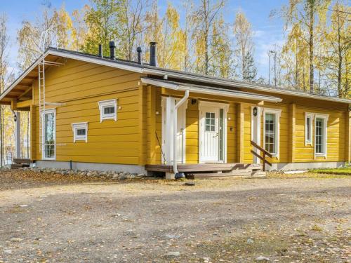 une petite maison jaune avec une terrasse couverte dans l'établissement Holiday Home Kolin mesikämmen by Interhome, à Kolinkylä