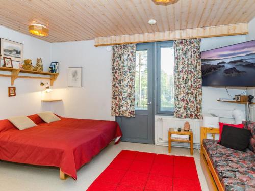 コリンカイラにあるHoliday Home Loma-koli 1 by Interhomeのベッドルーム(赤いベッド1台、ソファ付)