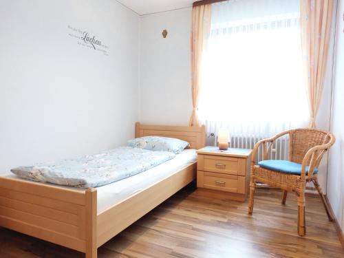 a bedroom with a bed and a chair and a window at Ferienwohnung Gaul in Riedenburg