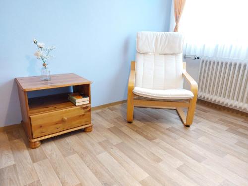 a chair and a table with a vase of flowers and a vase at Ferienwohnung Gaul in Riedenburg