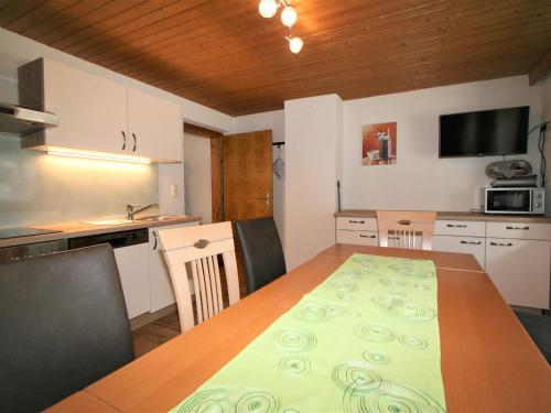 eine Küche mit einem Holztisch und eine Küche mit einem Tisch und Stühlen in der Unterkunft Apartment Unterflöber-1 by Interhome in Großhartberg