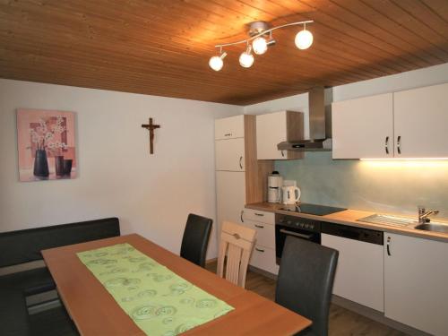 eine Küche mit einem Tisch und einem Kreuz an der Wand in der Unterkunft Apartment Unterflöber-1 by Interhome in Großhartberg