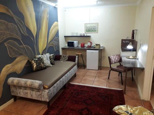 - un salon avec un canapé et une table dans l'établissement Beit-El BnB, à Polokwane