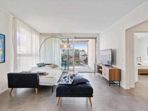 a bedroom with a bed and a room with a view at Apartment LocTowers A4-3-4 by Interhome in Locarno