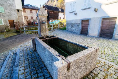 a water fountain in the middle of a street at Chalet Nucleo 12 by Quokka 360 - bouldering temple in Chironico in Chironico