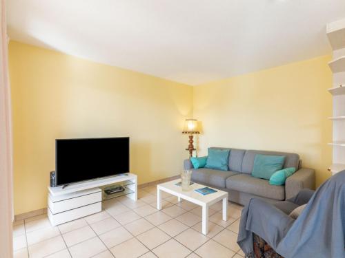 un salon avec un canapé et une télévision à écran plat dans l'établissement Apartment Le Timothée by Interhome, à Saint-Aygulf