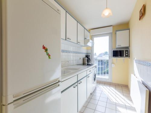 une cuisine avec des placards blancs et une grande fenêtre dans l'établissement Apartment Le Timothée by Interhome, à Saint-Aygulf