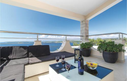 a balcony with a couch and two glasses of wine at 2 Bedroom Amazing Home In Vela Luka in Vela Luka