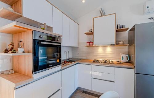 a kitchen with white cabinets and a stainless steel refrigerator at 2 Bedroom Amazing Home In Vela Luka in Vela Luka