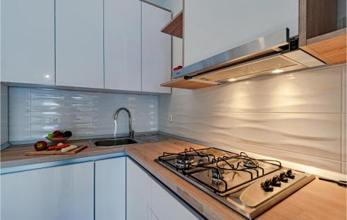 a kitchen with white cabinets and a stove top oven at 2 Bedroom Amazing Home In Vela Luka in Vela Luka