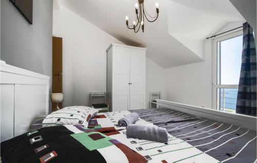 a bedroom with a bed and a chandelier at 2 Bedroom Amazing Home In Vela Luka in Vela Luka