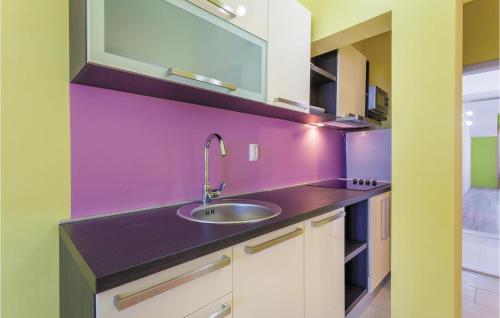 a kitchen with a sink and a purple wall at Beautiful Apartment In Kastel Stafilic With 5 Bedrooms, Wifi And Outdoor Swimming Pool in Kaštela