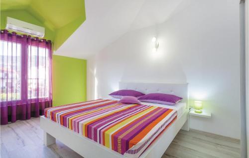 a bedroom with a bed with a colorful striped blanket at Beautiful Apartment In Kastel Stafilic With 5 Bedrooms, Wifi And Outdoor Swimming Pool in Kaštela