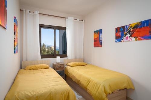 マニルバにあるBeach Apartment Marina Duquesaのベッドルーム1室(ベッド2台、窓付)