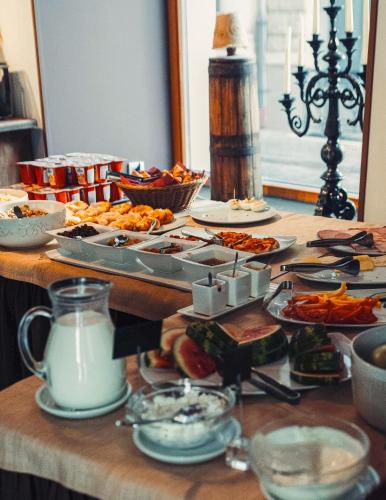 a table with many plates of food on it at Boutique Hotel Justus in Rīga
