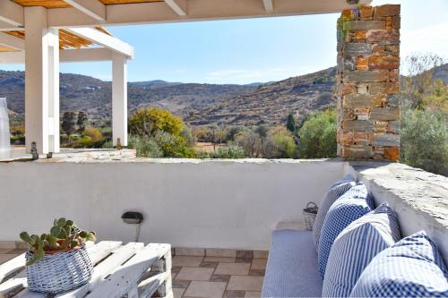 a porch with blue and white furniture and a view of the mountains at Alexandrea, family home near Vourkari on the island of Kea in Ioulida