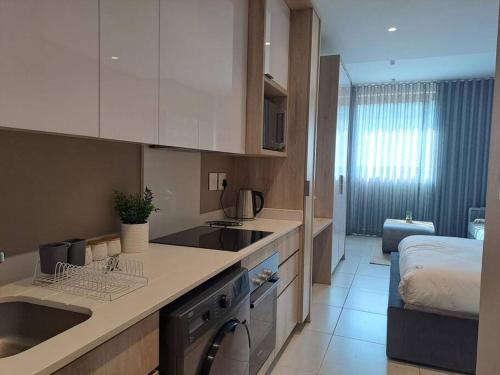 Una cocina con fregadero y una cama en una habitación. en Zimbali Lakes Boulevard Suites 261, en Ballito
