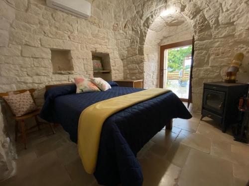 een slaapkamer met een bed en een stenen muur bij Trullo Incanto in Ostuni