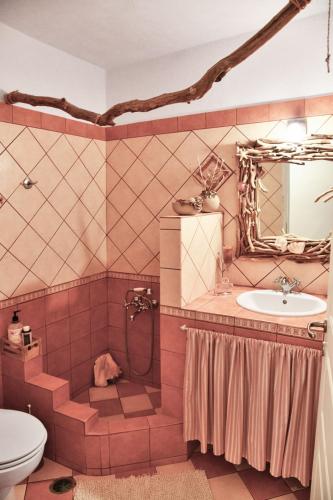 a bathroom with a sink and a toilet and a mirror at Alexandrea, family home near Vourkari on the island of Kea in Ioulida