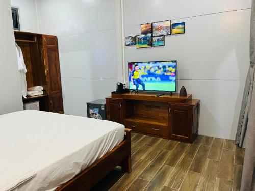 a bedroom with a bed and a flat screen tv at SuMin Homestay in Phú Quốc