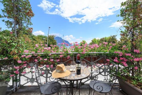 a table with a hat on a balcony with flowers at Casa alle Colonne by Hotel Ancora in Verbania