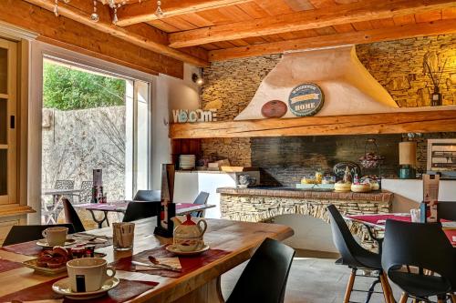 Una cocina con mesa y sillas de madera y chimenea. en Contact Hôtel Le Provence, en Gémenos