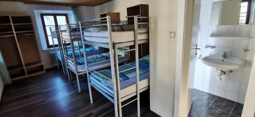 a room with three bunk beds and a sink at Gasthof Hirschen in Pfunds