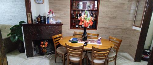 a dining room table with chairs and a fireplace at FAGO in Artigas