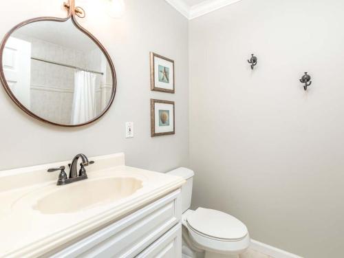 a white bathroom with a sink and a mirror at Nautical Watch in Tybee Island