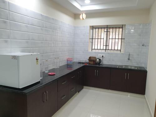 uma grande cozinha com um balcão e uma janela em Kanmani Elite- A Perfect Home em Tiruchchirappalli
