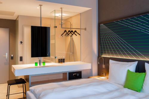 a bedroom with a sink and a bed and a mirror at elaya hotel kevelaer in Kevelaer
