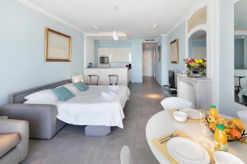 une grande chambre avec un lit et un salon dans l'établissement Palais Miramar - Suite Blue Room - Vue Mer -Croisette Emplacement Unique - 20M Plage - WIFI - Clim, à Cannes